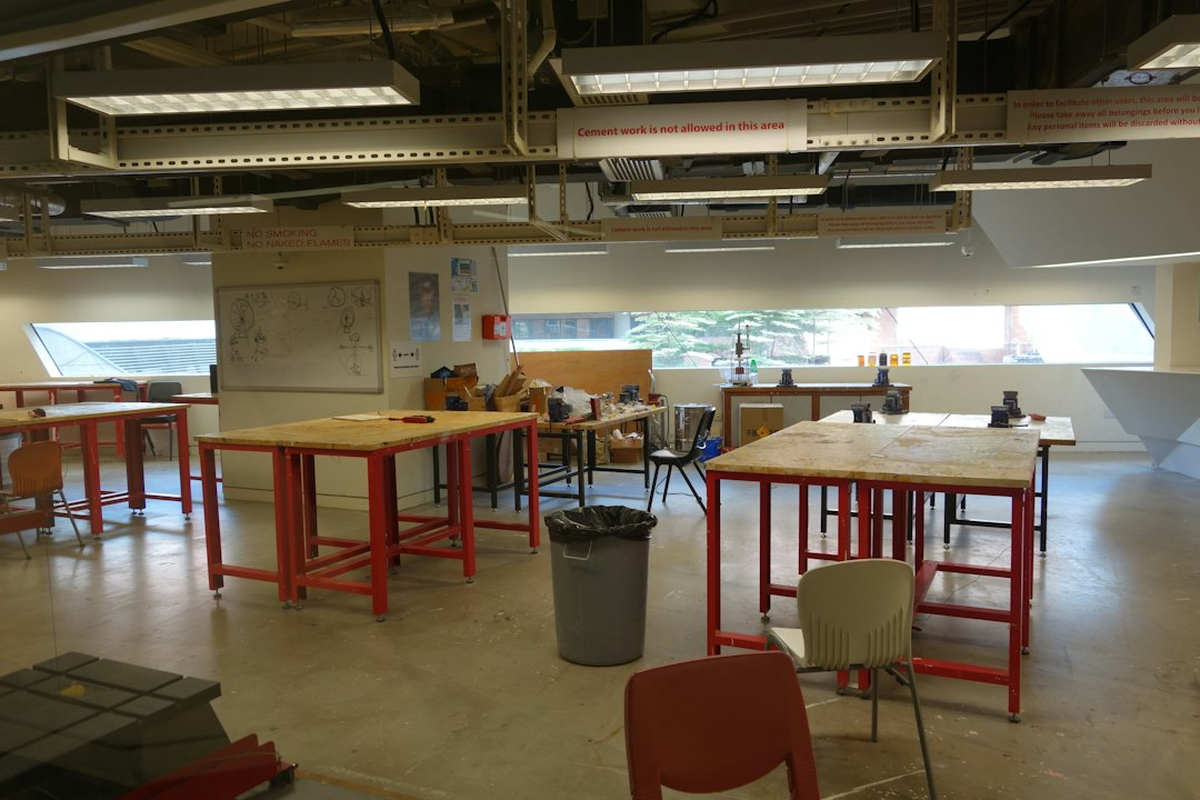 Teams of adults working at task stations with printed clue sheets on a long table