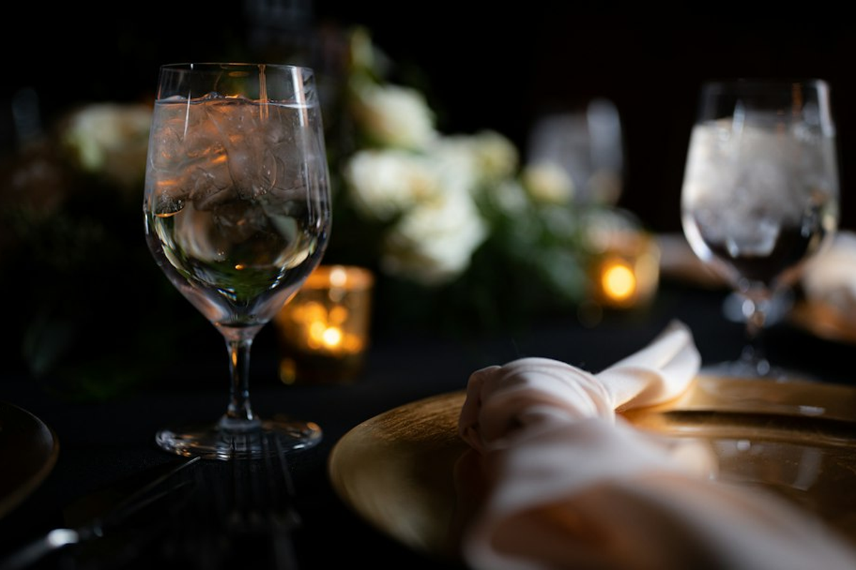 Long dressed dining table lit by candles and warm pendant light, set for a private celebration